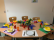 Ein bunt gedeckter Tisch mit Blumen, Tellern, Besteck und Bechern