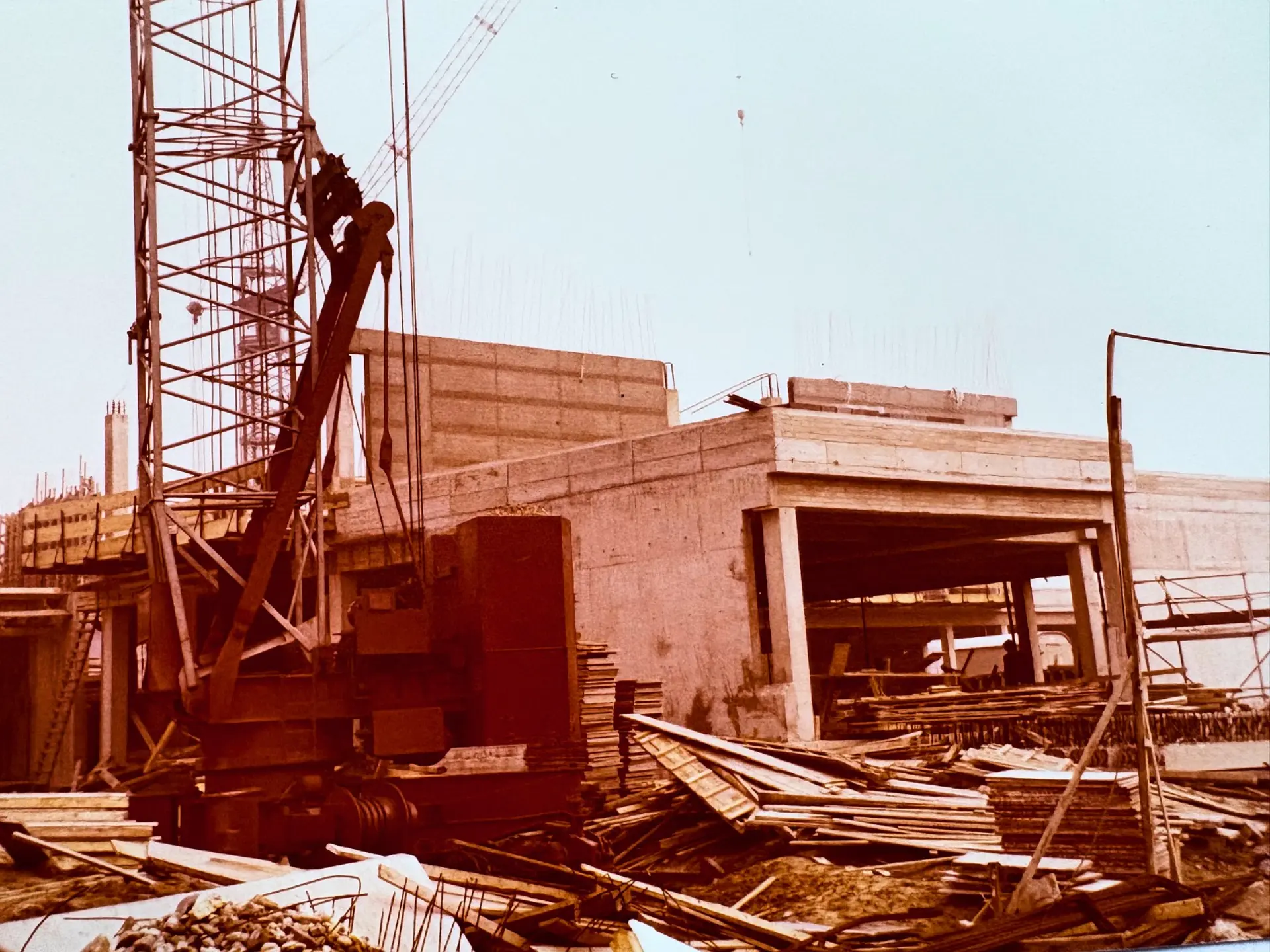 Eine alte Aufnahme von der Baustelle des aktuellen Schulgebäudes aus dem Jahr 1978. Darauf sind ein großer Kran, viele Beton- und Holzplatten zu sehen.
