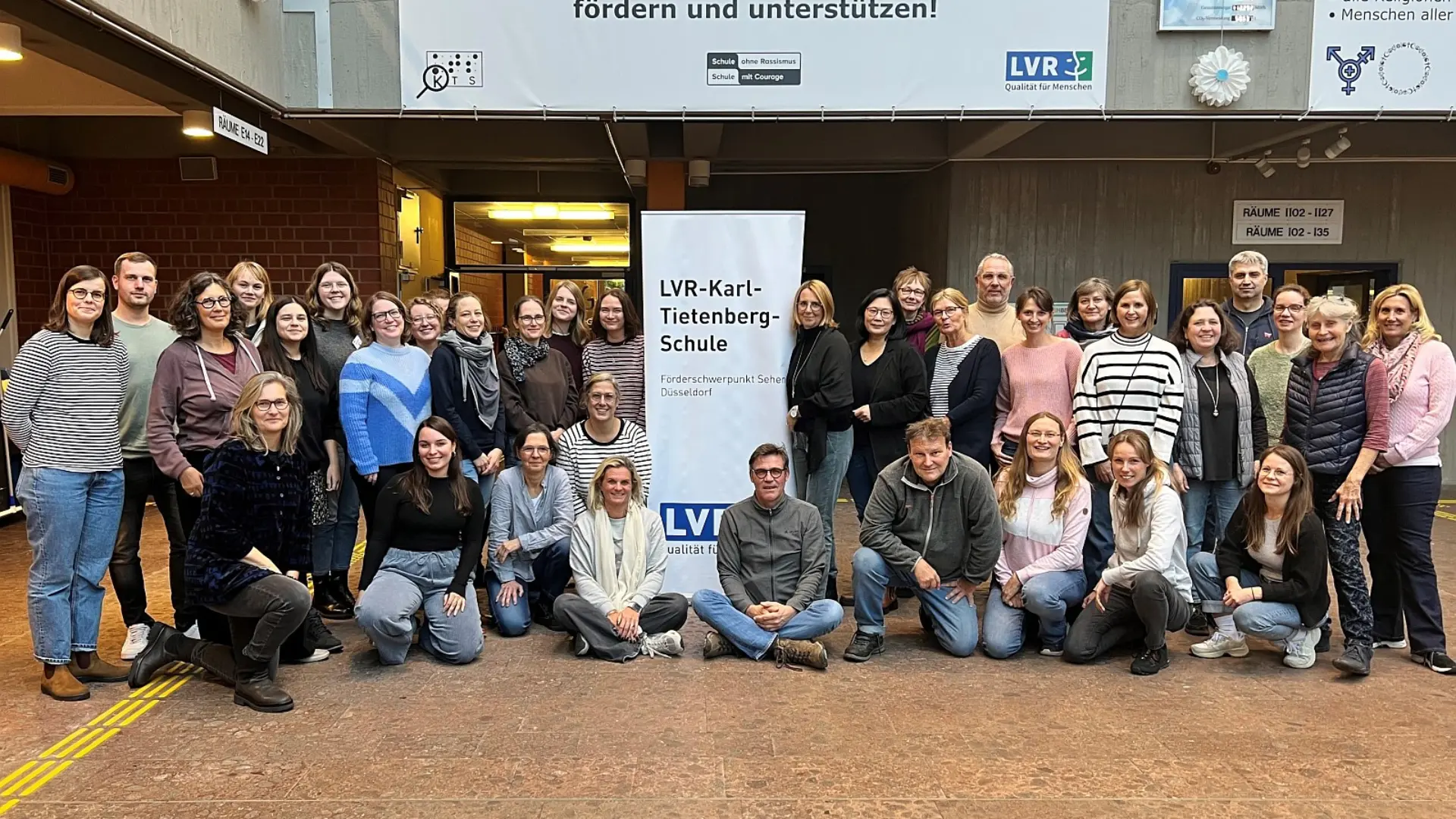 Ein Gruppenporträt des gesamten Kollegiums im Foyer der LVR-Karl-Tietenberg-Schule