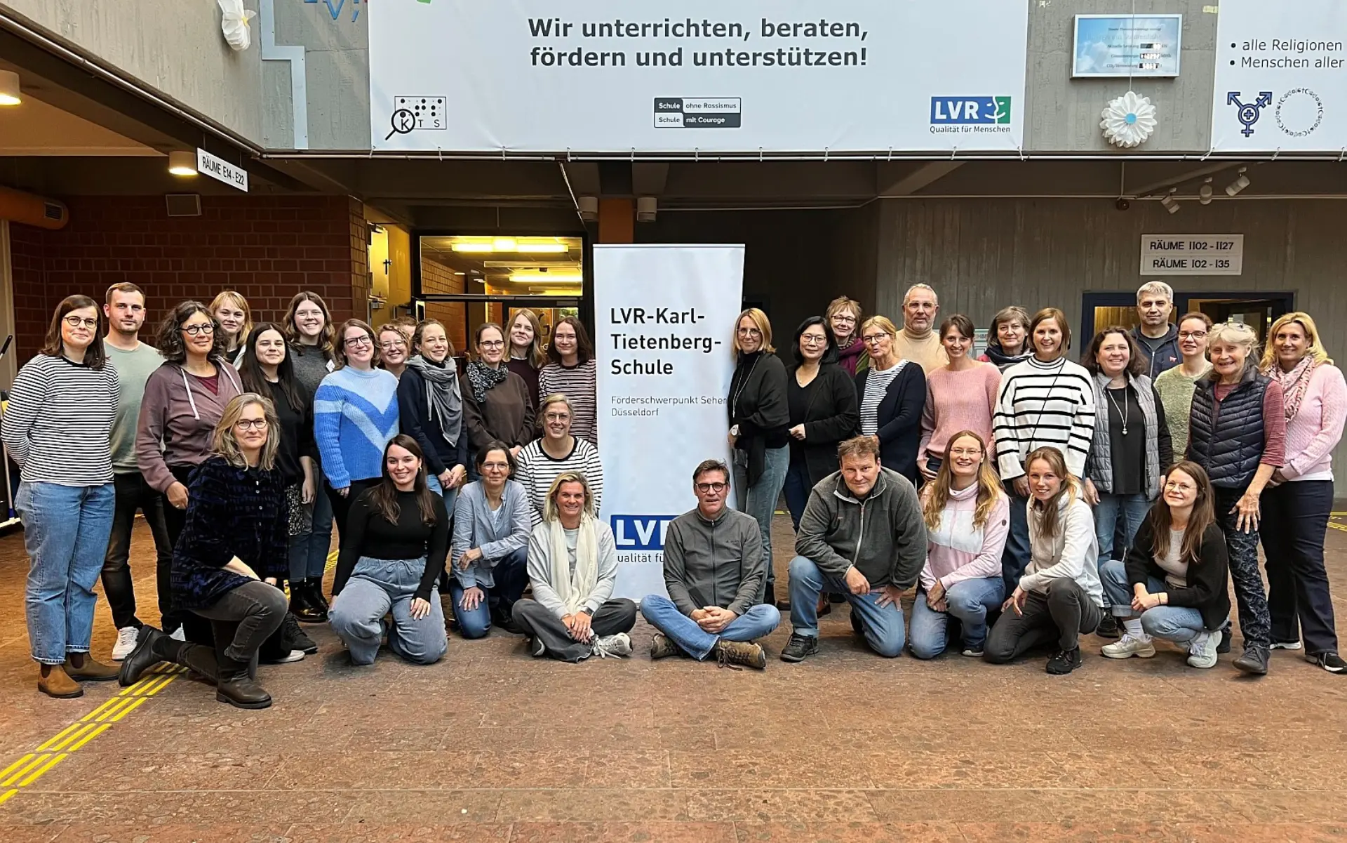 Ein Gruppenporträt des gesamten Kollegiums im Foyer der LVR-Karl-Tietenberg-Schule